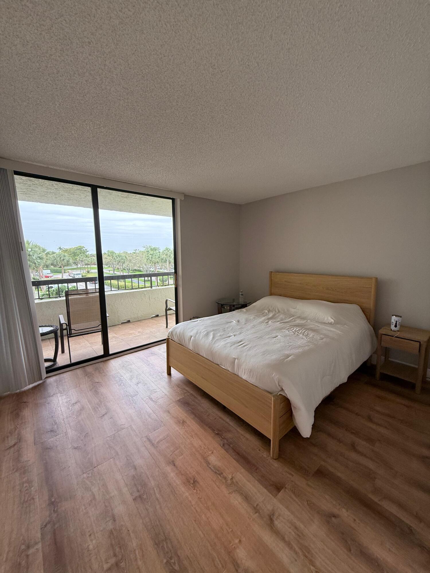 6372 La Costa Drive, Unit 306 Boca Raton, FL 33433 - Photo 16 of 23 a large bed sitting in a bedroom next to a large window