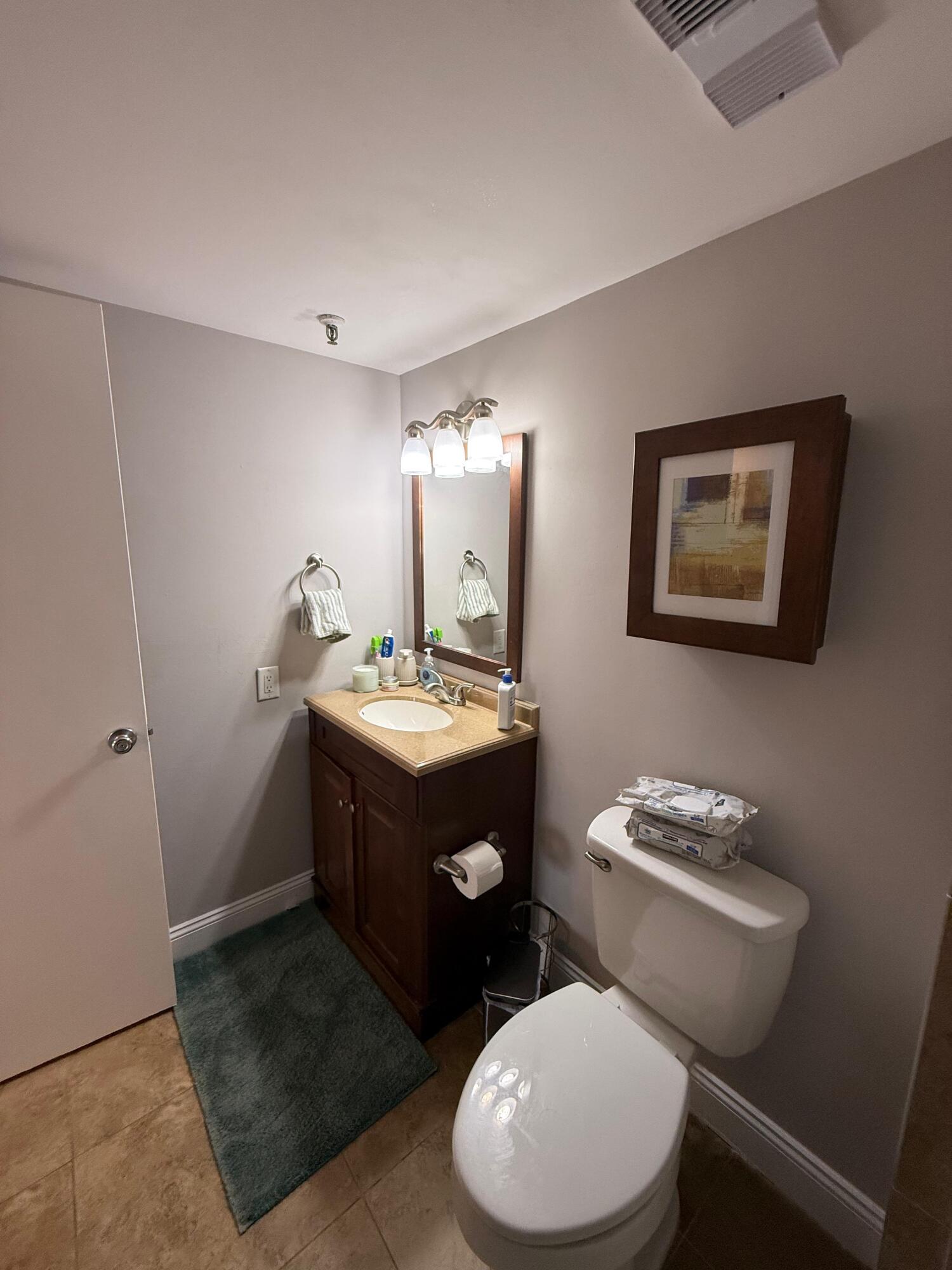 6372 La Costa Drive, Unit 306 Boca Raton, FL 33433 - Photo 20 of 23 a bathroom with a toilet a sink and mirror