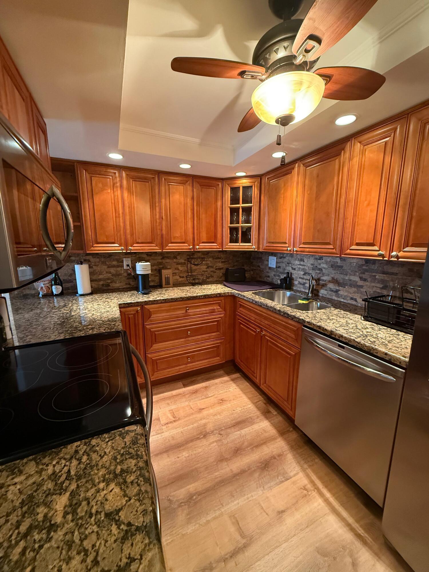6372 La Costa Drive, Unit 306 Boca Raton, FL 33433 - Photo 6 of 23 a kitchen with stainless steel appliances granite countertop a sink stove window and cabinets