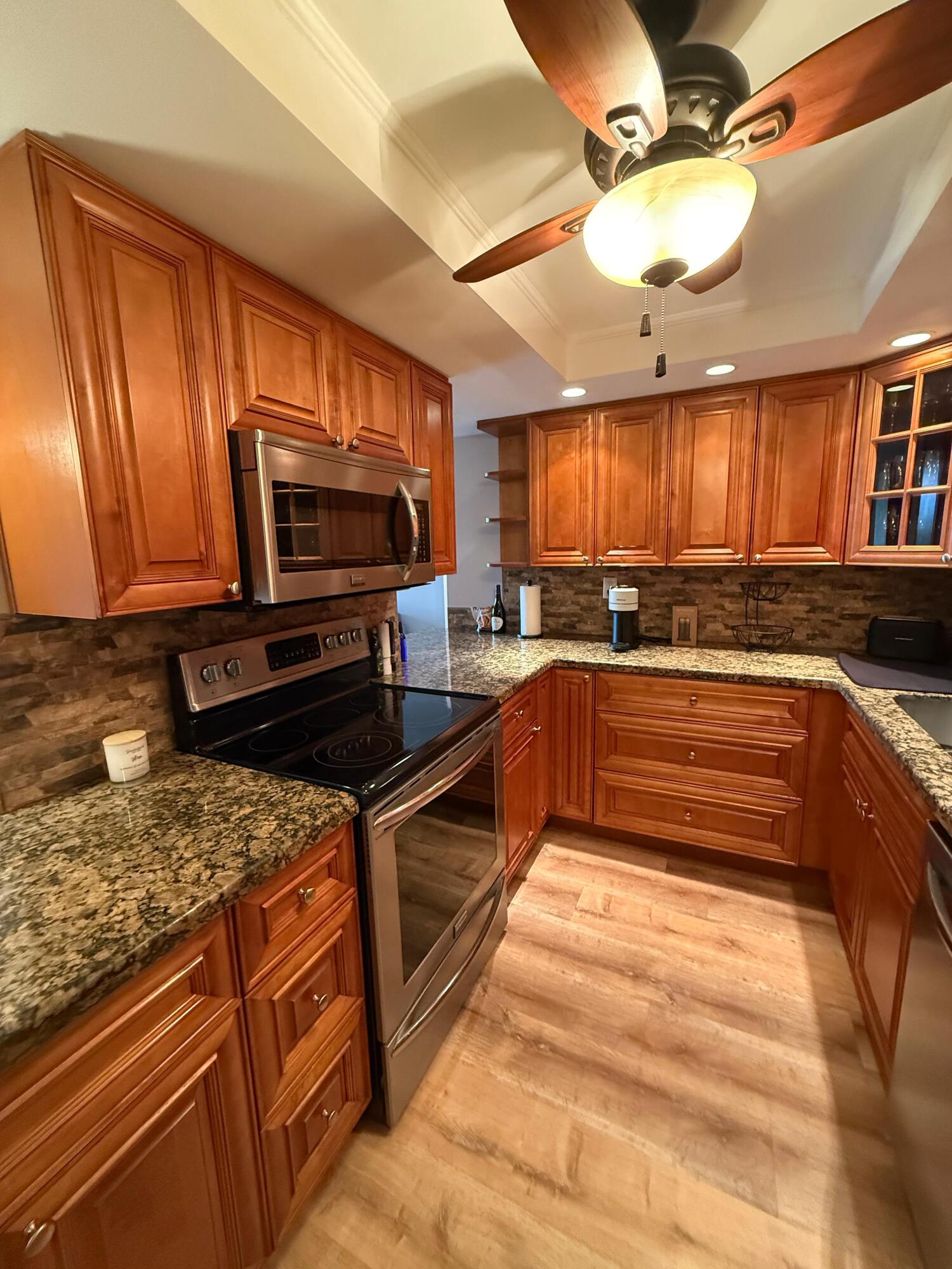 6372 La Costa Drive, Unit 306 Boca Raton, FL 33433 - Photo 8 of 23 a kitchen with stainless steel appliances granite countertop a stove sink and microwave