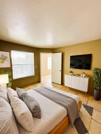 a bedroom with a bed and a flat screen tv