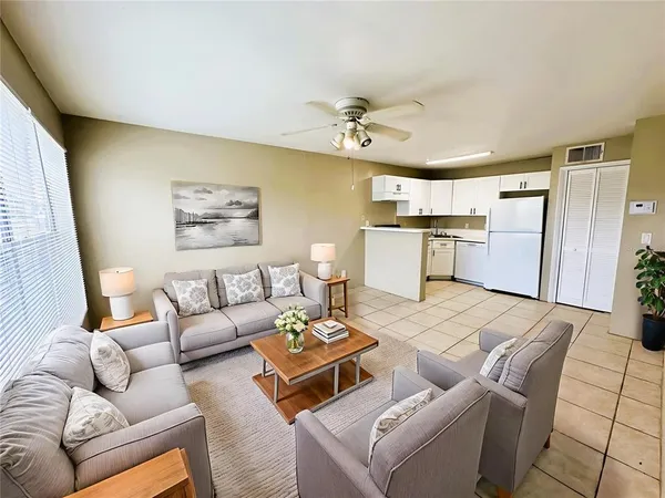 a living room with furniture and kitchen view