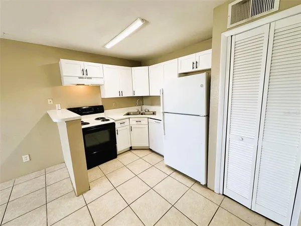 a kitchen with white cabinets and white appliances