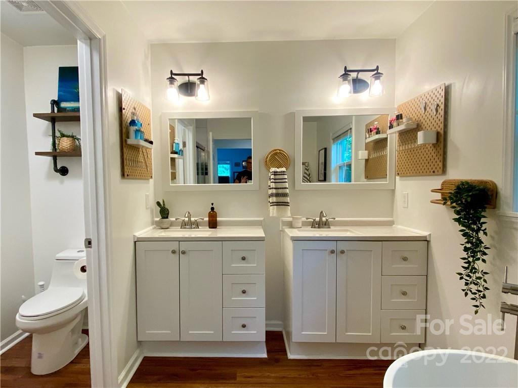1240 Skyview Road Charlotte, NC 28208 - Photo 20 of 30 a spacious bathroom with a toilet sink and mirror