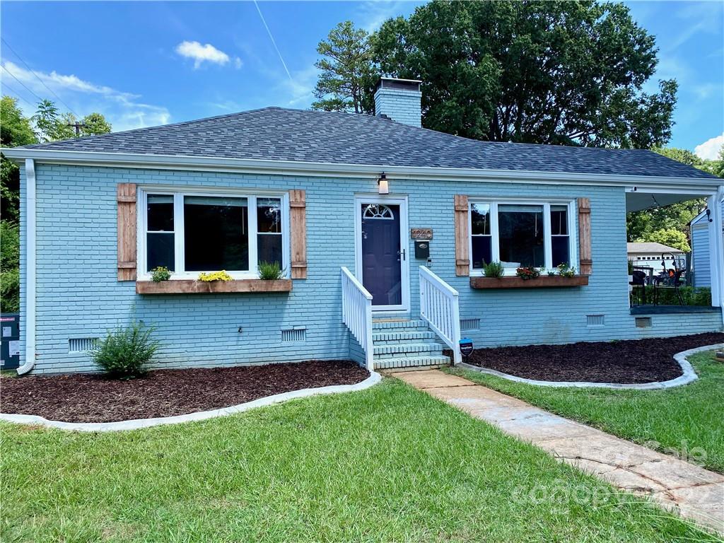 1240 Skyview Road Charlotte, NC 28208 - Photo 28 of 30 a view of a house with a yard potted plants and a table
