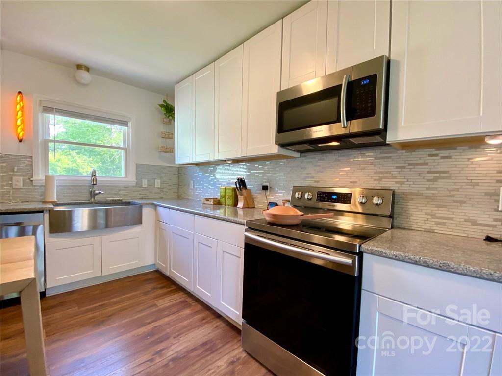 1240 Skyview Road Charlotte, NC 28208 - Photo 7 of 30 a kitchen with stainless steel appliances wooden cabinets stove and a sink
