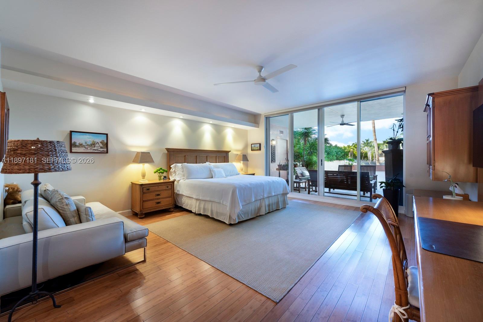 765 Crandon Boulevard, Unit 102 Key Biscayne, FL 33149 - Photo 13 of 37 a bedroom with furniture and a flat screen tv