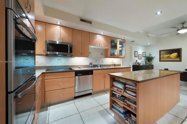 a kitchen with stainless steel appliances granite countertop a sink counter space cabinets and a large window