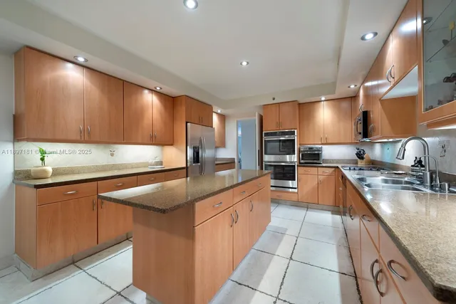 a kitchen with stainless steel appliances granite countertop a refrigerator a stove a sink dishwasher with a dining table and chairs