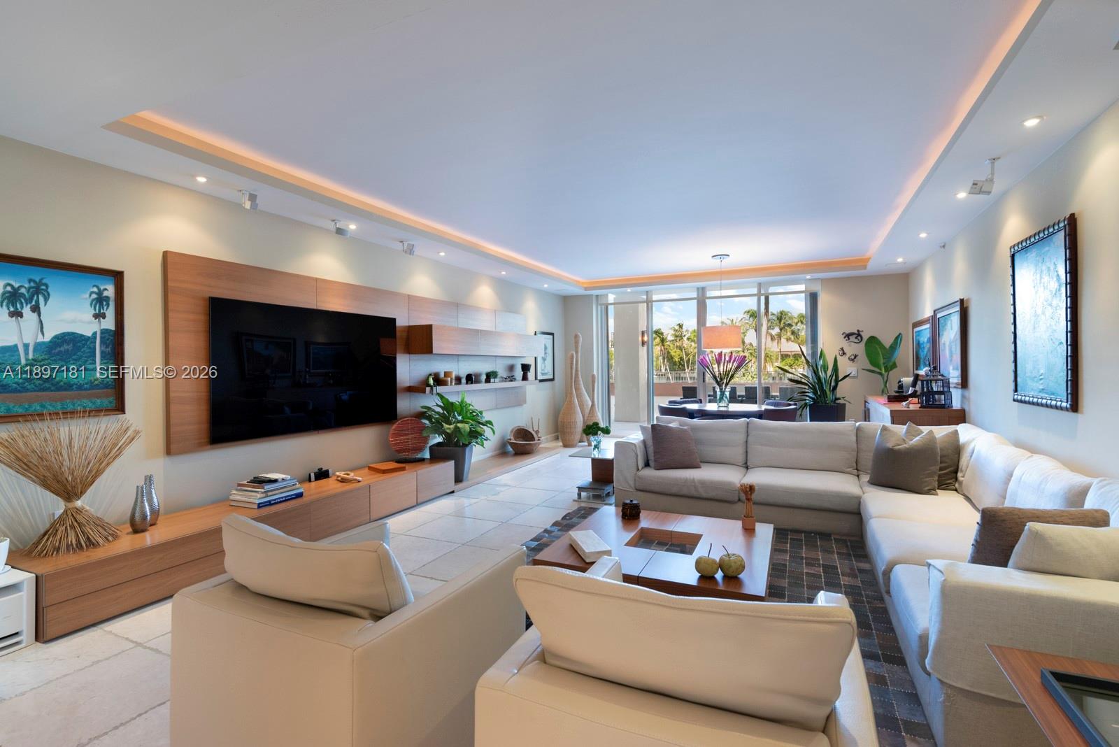 765 Crandon Boulevard, Unit 102 Key Biscayne, FL 33149 - Photo 3 of 37 a living room with furniture and a flat screen tv