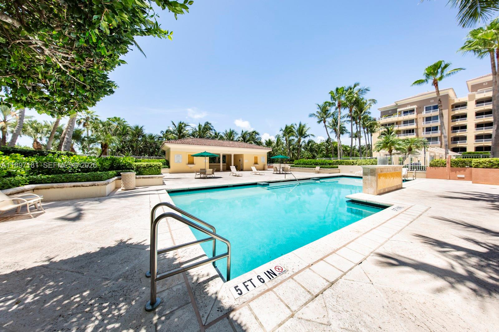 765 Crandon Boulevard, Unit 102 Key Biscayne, FL 33149 - Photo 34 of 37 a view of a swimming pool with a patio and a yard