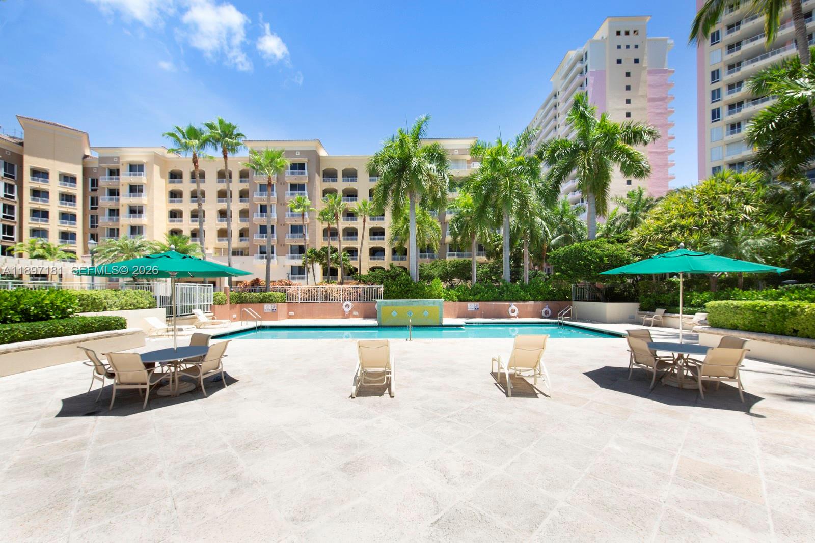 765 Crandon Boulevard, Unit 102 Key Biscayne, FL 33149 - Photo 35 of 37 a view of a swimming pool with a patio and a yard