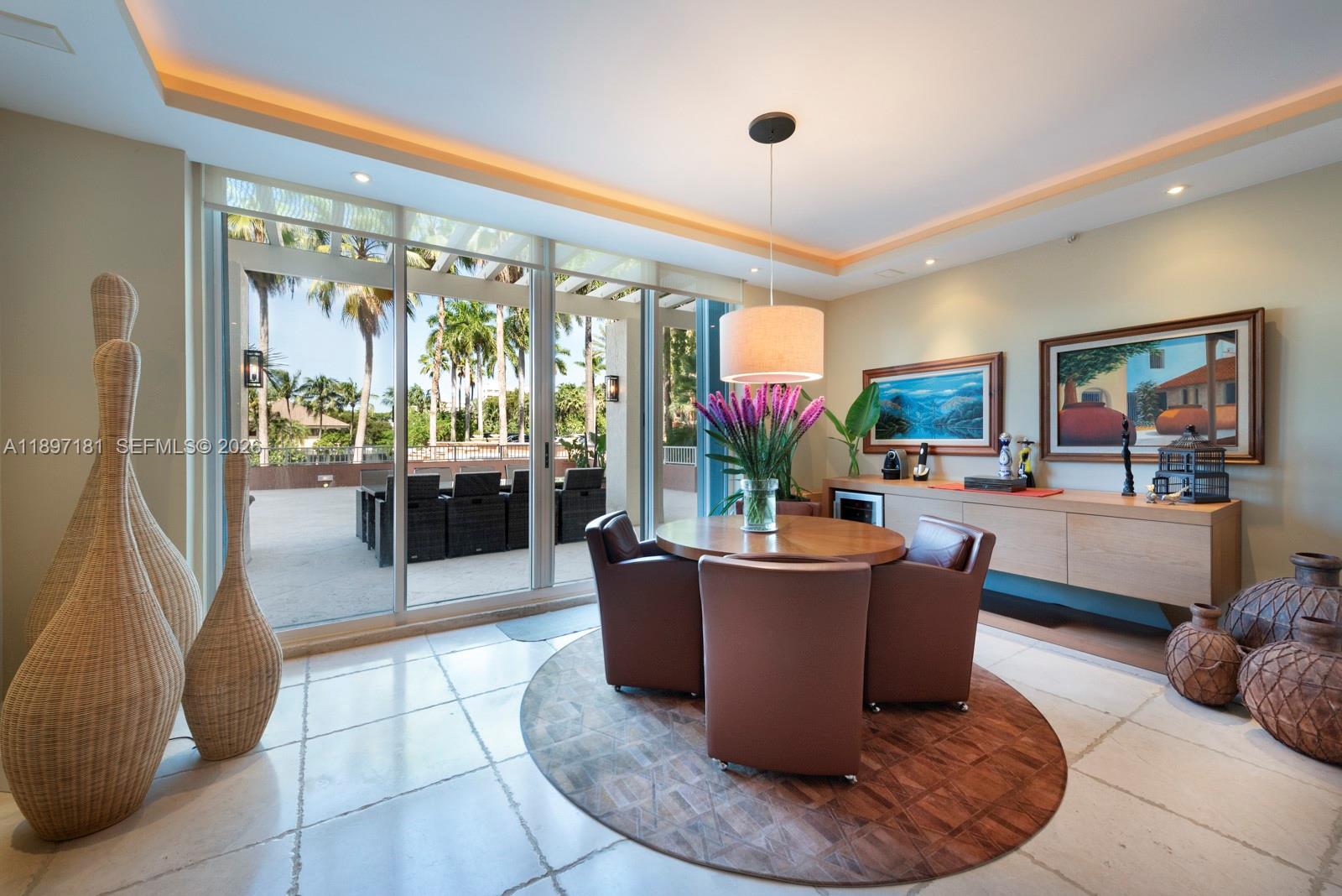 765 Crandon Boulevard, Unit 102 Key Biscayne, FL 33149 - Photo 5 of 37 a living room with furniture a flat screen tv and a large window