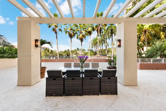 a view of a patio with table and chairs potted plants and palm trees