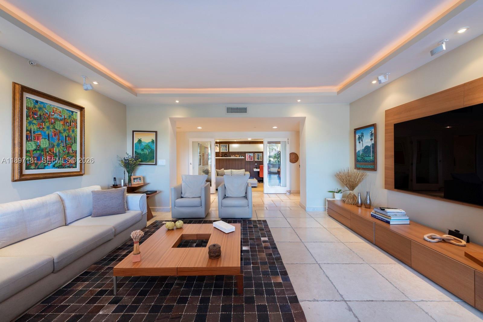 765 Crandon Boulevard, Unit 102 Key Biscayne, FL 33149 - Photo 8 of 37 a living room with furniture and a flat screen tv