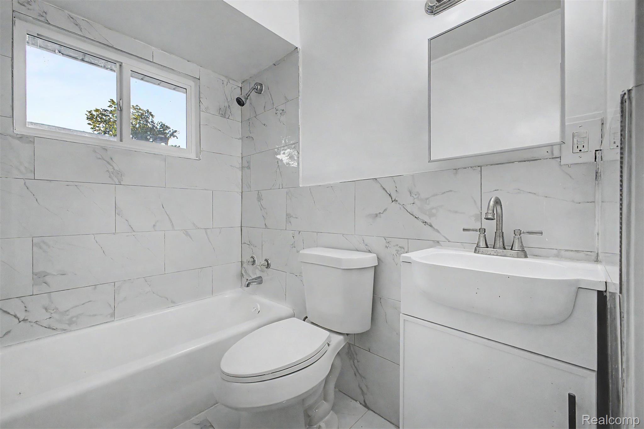 26718 Penn Street Inkster, MI 48141 - Photo 12 of 27 Bathroom featuring a white bathtub, toilet, and vanity with an integrated sink