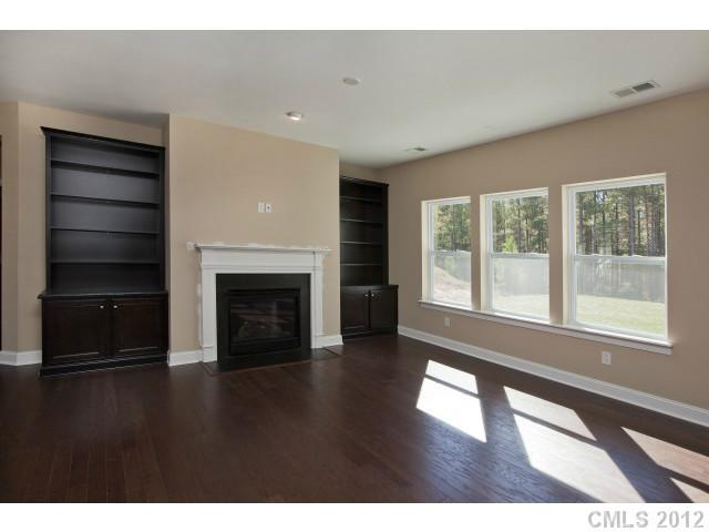 86587 Arrington Road, Unit 101 Lancaster, SC 29720 - Photo 6 of 16 a view of an empty room with wooden floor fireplace and a window