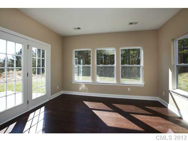 86587 Arrington Road, Unit 101 Lancaster, SC 29720 - Photo 10 of 16 an empty room with wooden floor and windows