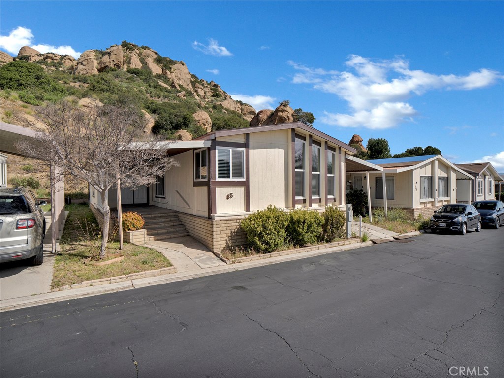 24303 Woolsey Canyon Road, Unit 85 West Hills, CA 91304 - Photo 22 of 31 a front view of a house with a garden