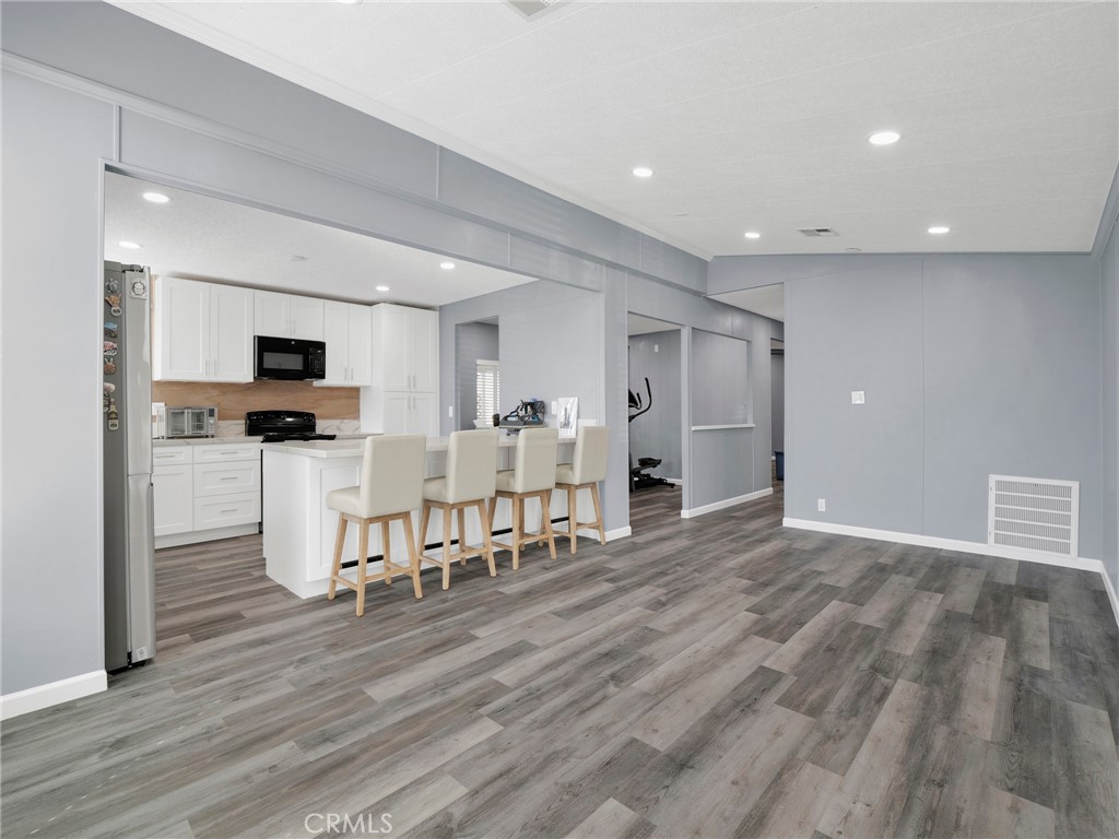 24303 Woolsey Canyon Road, Unit 85 West Hills, CA 91304 - Photo 3 of 31 a view of kitchen with refrigerator microwave and wooden floor