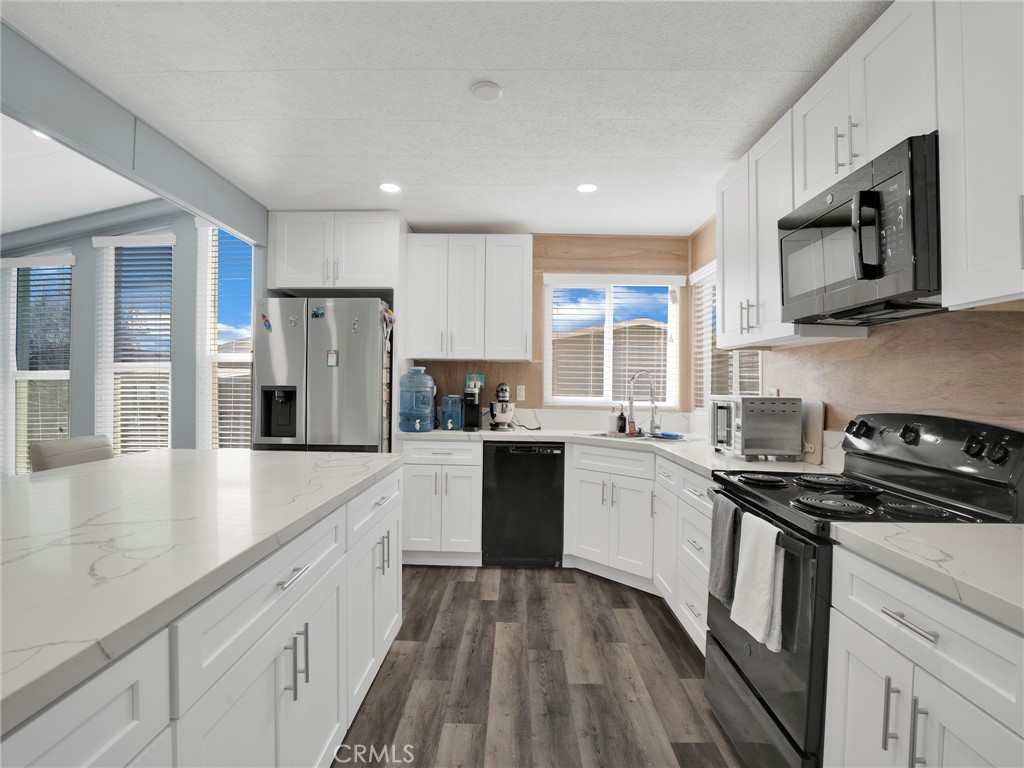 24303 Woolsey Canyon Road, Unit 85 West Hills, CA 91304 - Photo 6 of 31 a kitchen with a stove a sink and a microwave