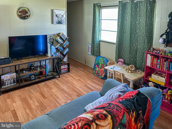 a living room with furniture a flat screen tv and a window