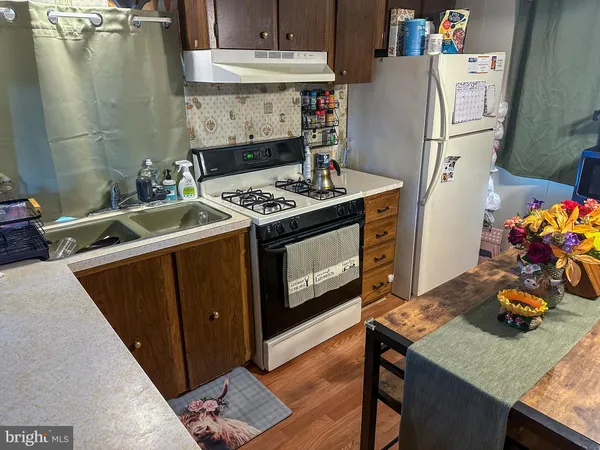 a kitchen with stainless steel appliances granite countertop a table a stove and a refrigerator