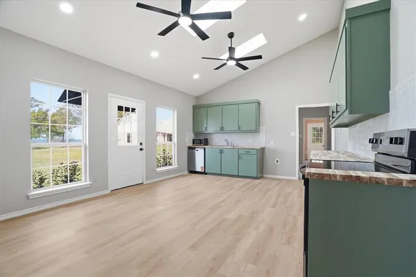 a view of a kitchen with microwave and windows