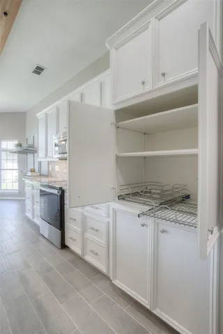 a kitchen with white cabinets and appliances