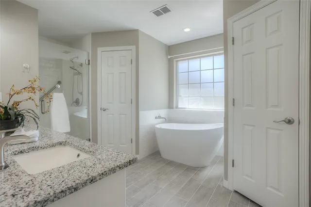 a white bath tub sitting in a bathroom next to a window