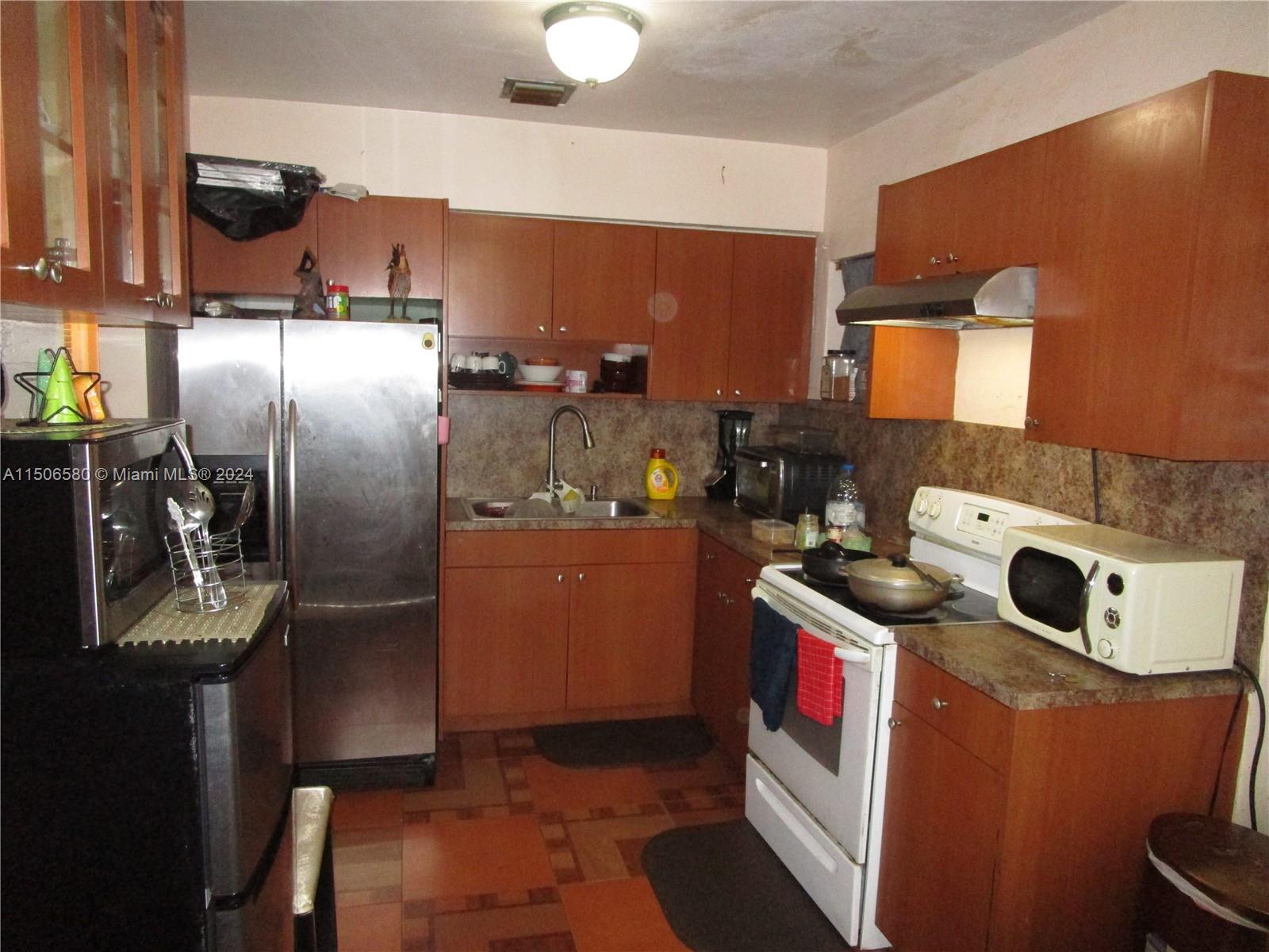 Westside North Miami, FL 33168 - Photo 4 of 13 a kitchen with stainless steel appliances a stove a refrigerator and a sink
