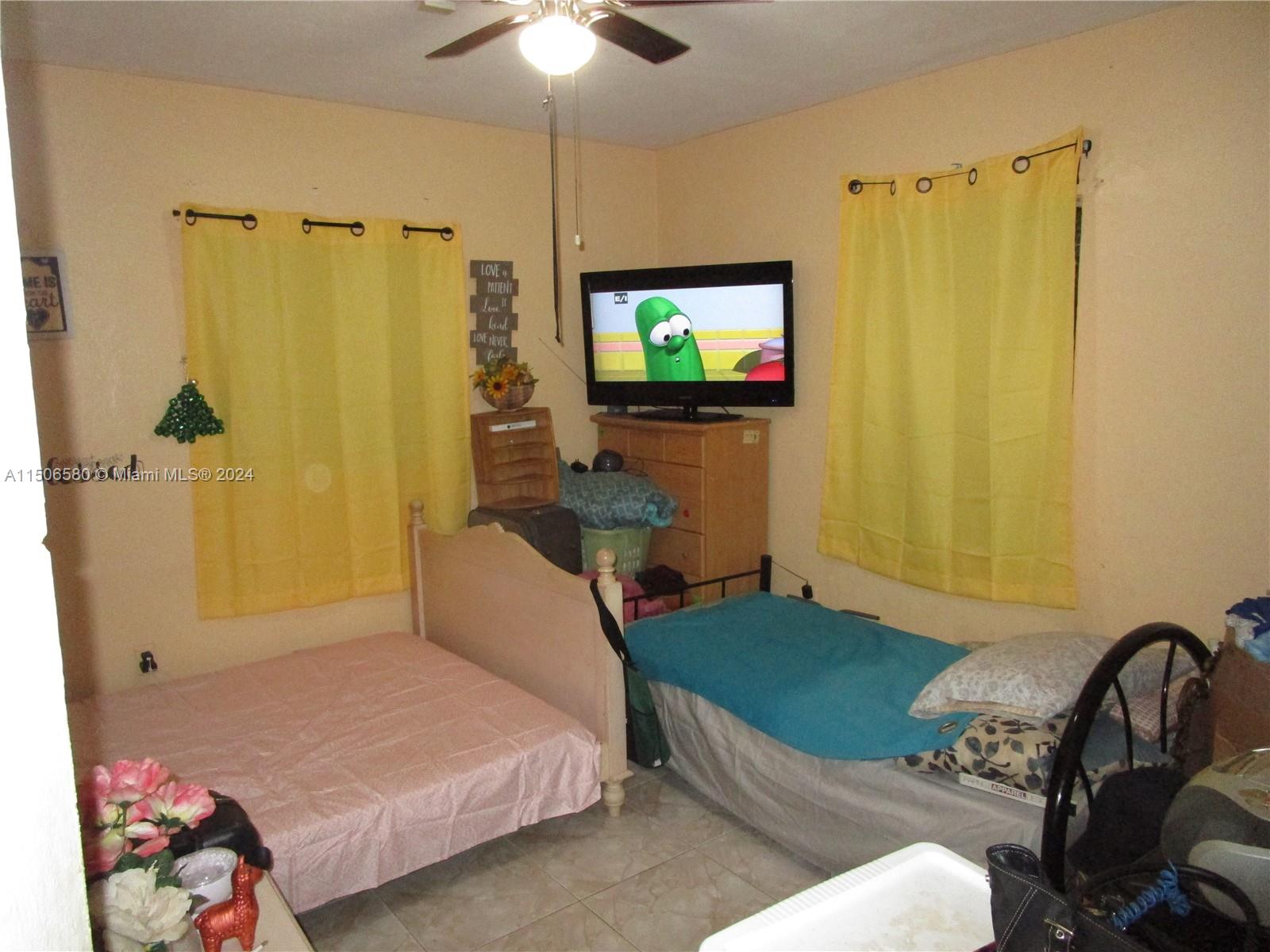 Westside North Miami, FL 33168 - Photo 10 of 13 a bedroom with a bed and a flat screen tv