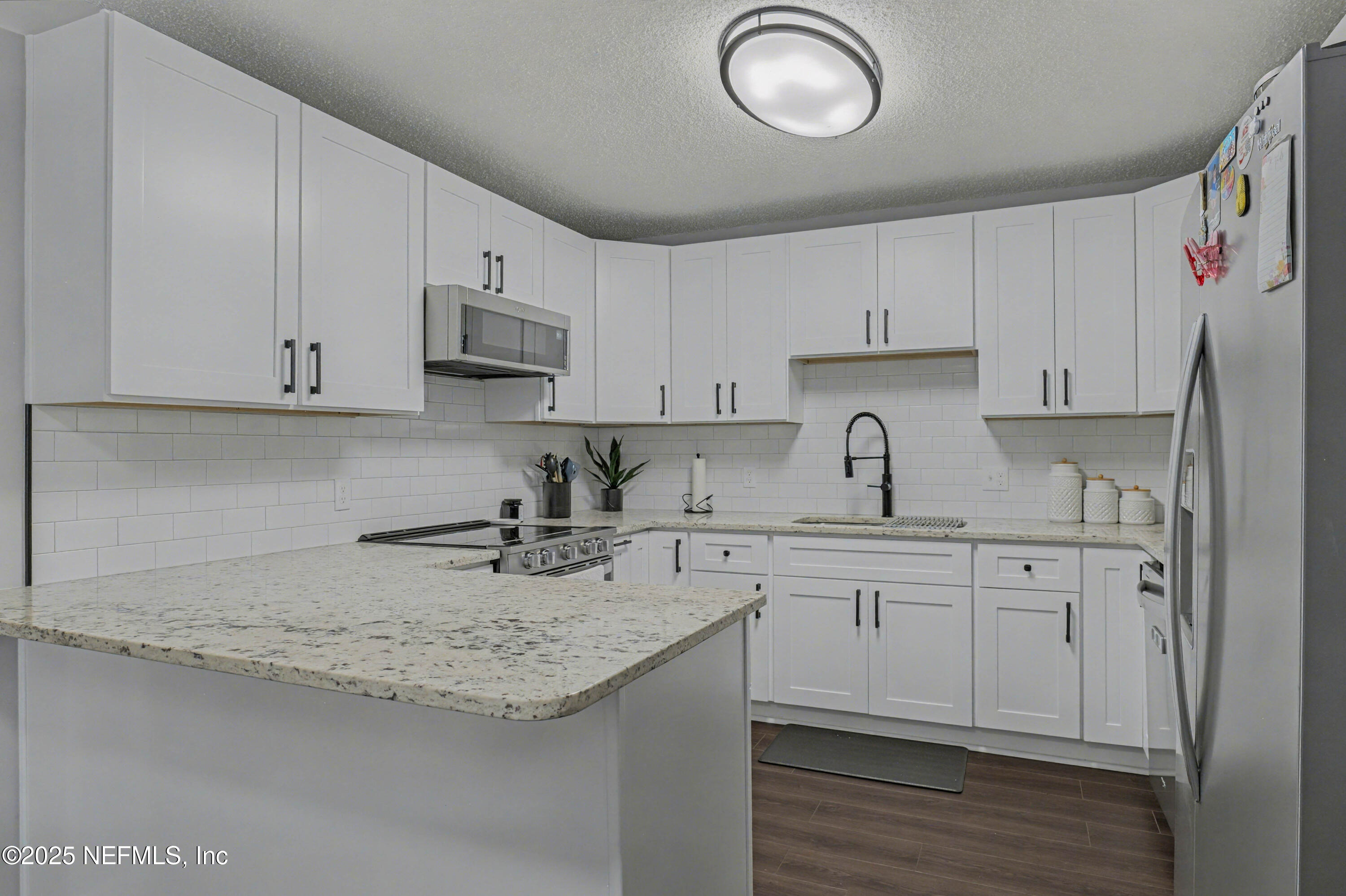 820 Golf Club Road Macclenny, FL 32063 - Photo 14 of 51 a kitchen with cabinets appliances a sink and a counter top space