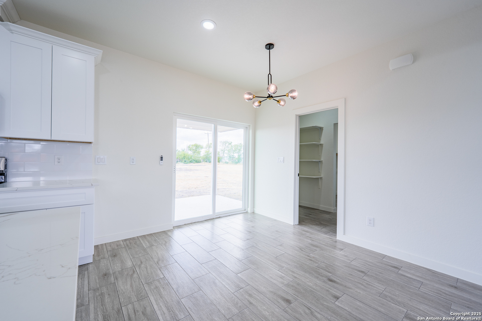 122 Ranchero Way Natalia, TX 78059 - Photo 14 of 31 a view of an empty room with a window and wooden floor
