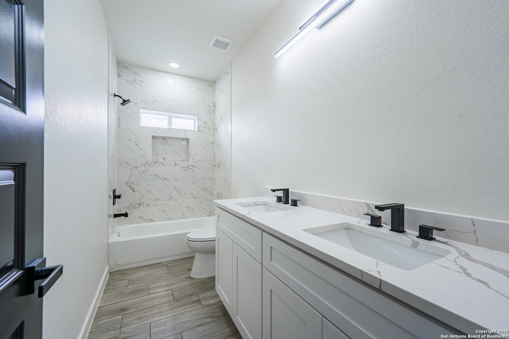 122 Ranchero Way Natalia, TX 78059 - Photo 22 of 31 a bathroom with a granite countertop sink a toilet and bathtub