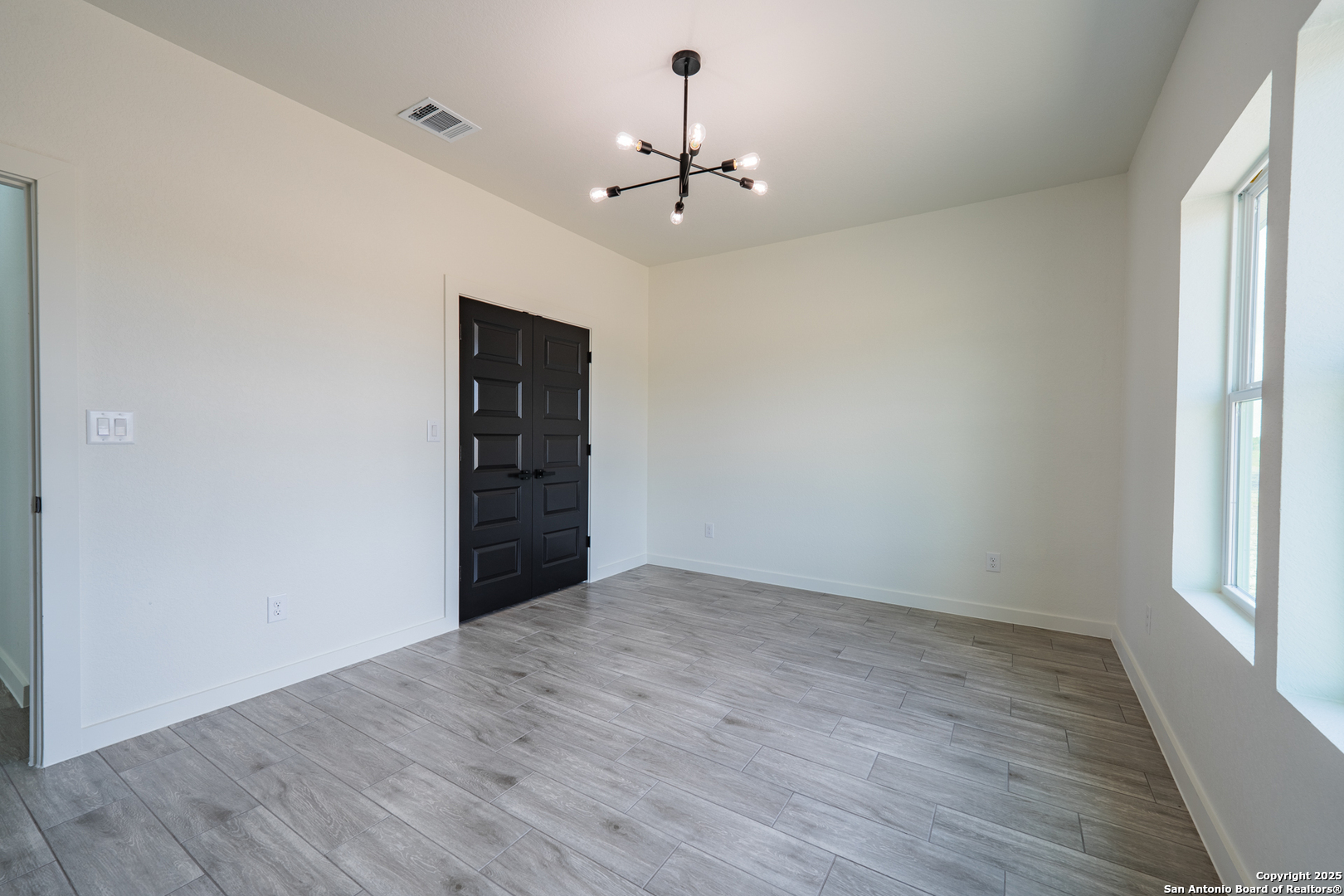 122 Ranchero Way Natalia, TX 78059 - Photo 23 of 31 wooden floor in an empty room with a window