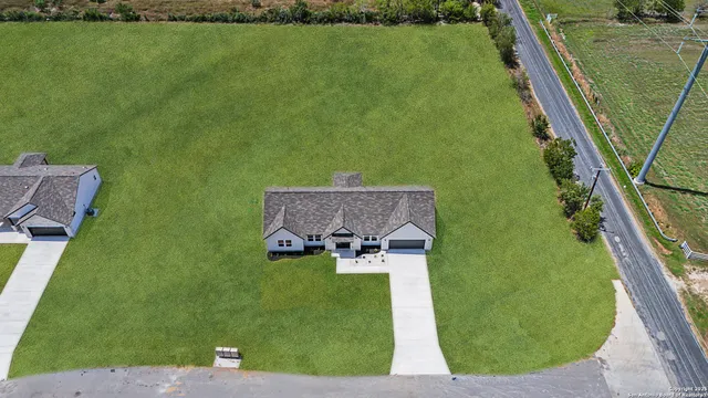 an aerial view of a house with a yard