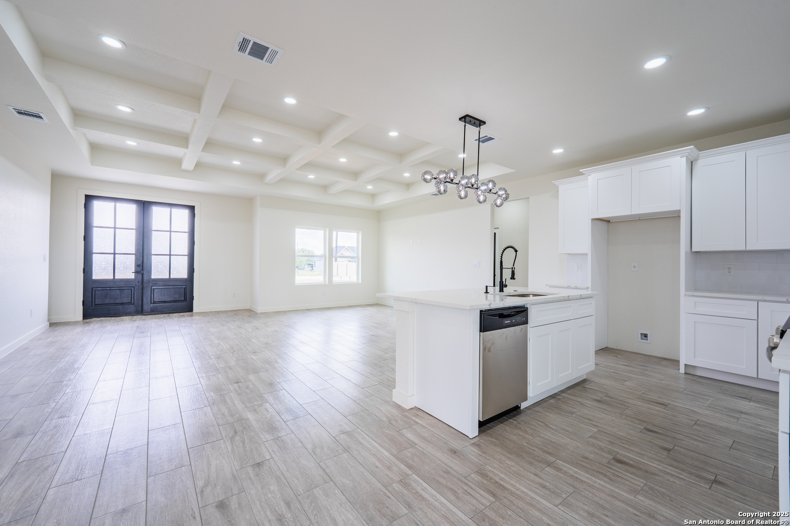 122 Ranchero Way Natalia, TX 78059 - Photo 4 of 31 a kitchen with stainless steel appliances wooden floors and white cabinets