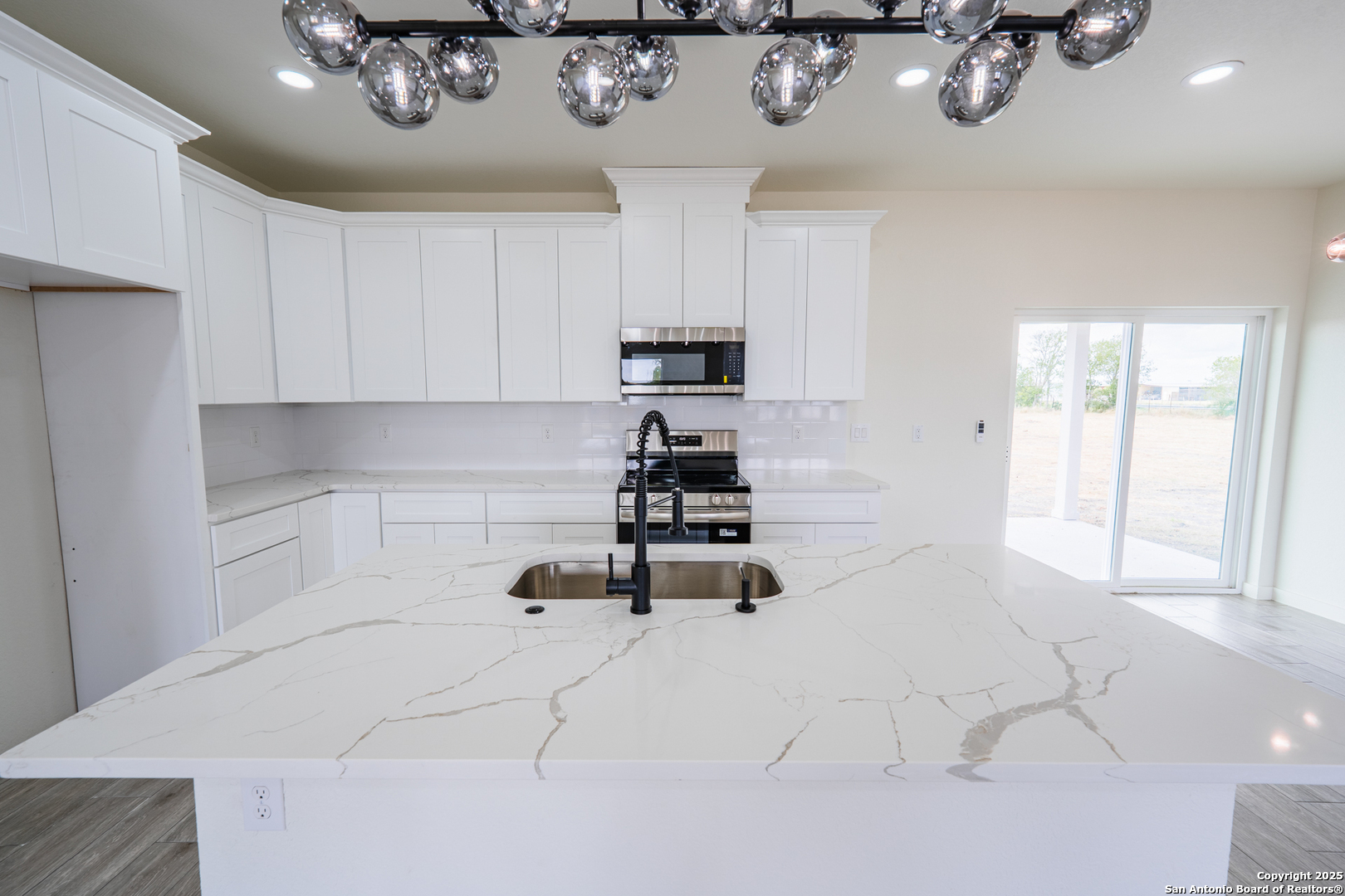 122 Ranchero Way Natalia, TX 78059 - Photo 5 of 31 a kitchen with a cabinets and chandelier