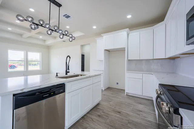 a kitchen with a sink stove and wooden floor