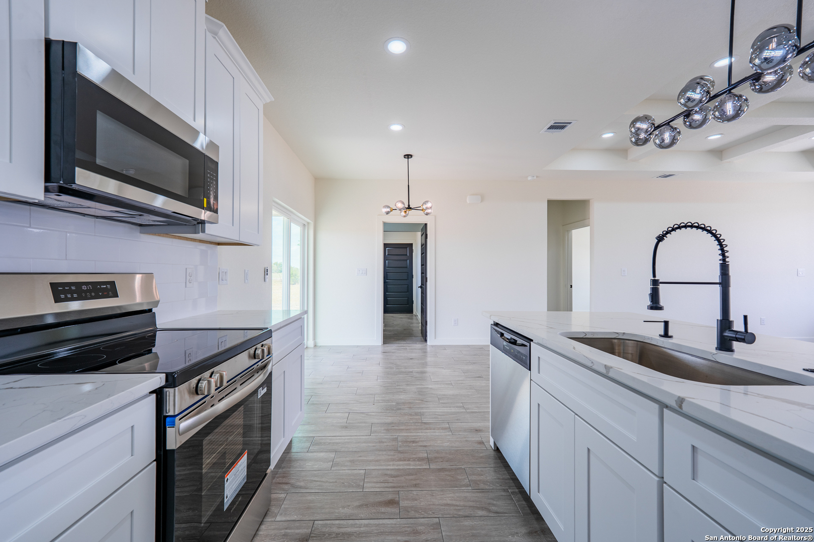 122 Ranchero Way Natalia, TX 78059 - Photo 8 of 31 a kitchen with stainless steel appliances granite countertop a sink and a microwave