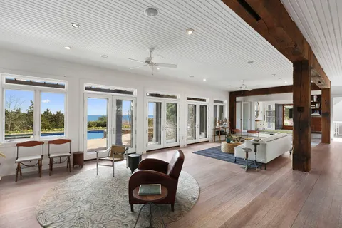 a living room with furniture large window and wooden floor