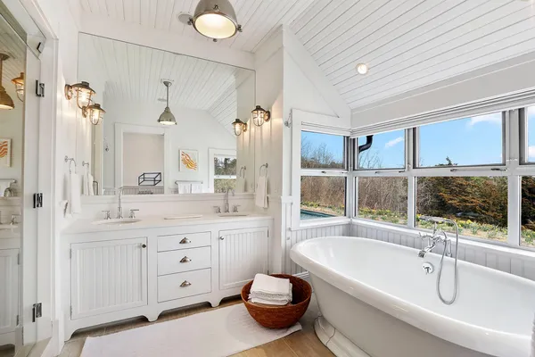 a bathroom with a tub sink toilet and mirror