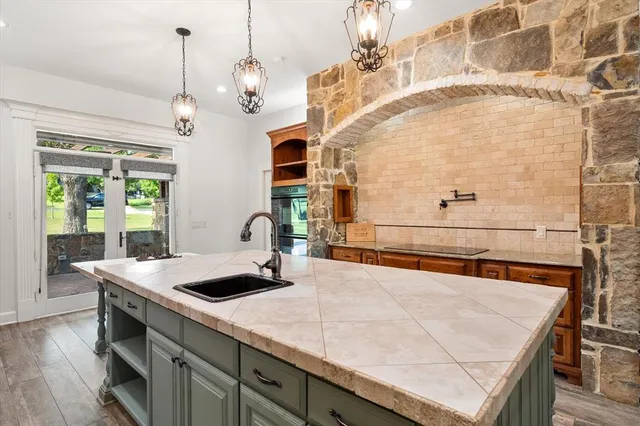 a view of a kitchen with a sink a counter top space and stainless steel appliances