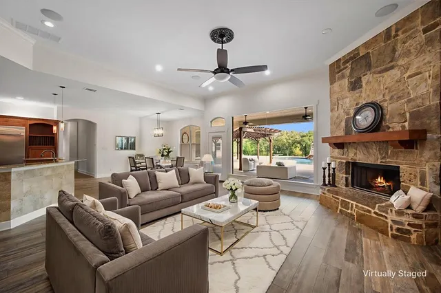 a living room with furniture a fireplace and a large window