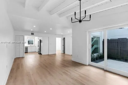 a view of a room with wooden floor ceiling fan and window