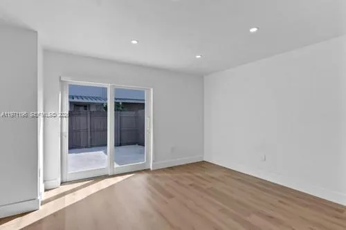 an empty room with wooden floor and door