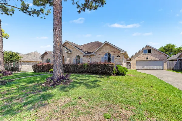 a view of a house with a big yard and large tree