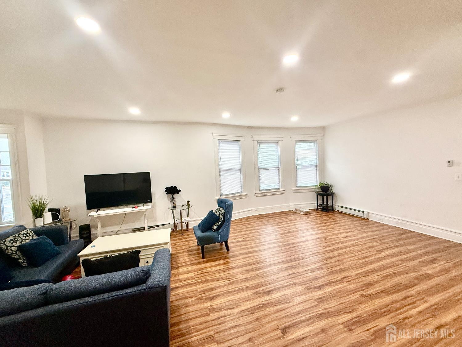 97 Lewis Street, Unit 99 Perth Amboy, NJ 08861 - Photo 3 of 4 a living room with furniture and a flat screen tv