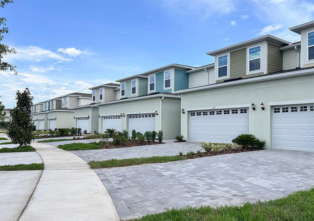 24101 Manuma Street, Unit SEMINOLE 2455 St. Cloud, FL 34771 - Photo 1 of 4 a front view of a house with a yard and a garage